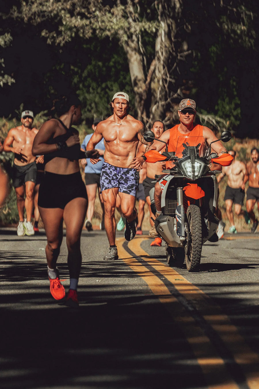Athletes running beside a support motorbike at HAOS training camp