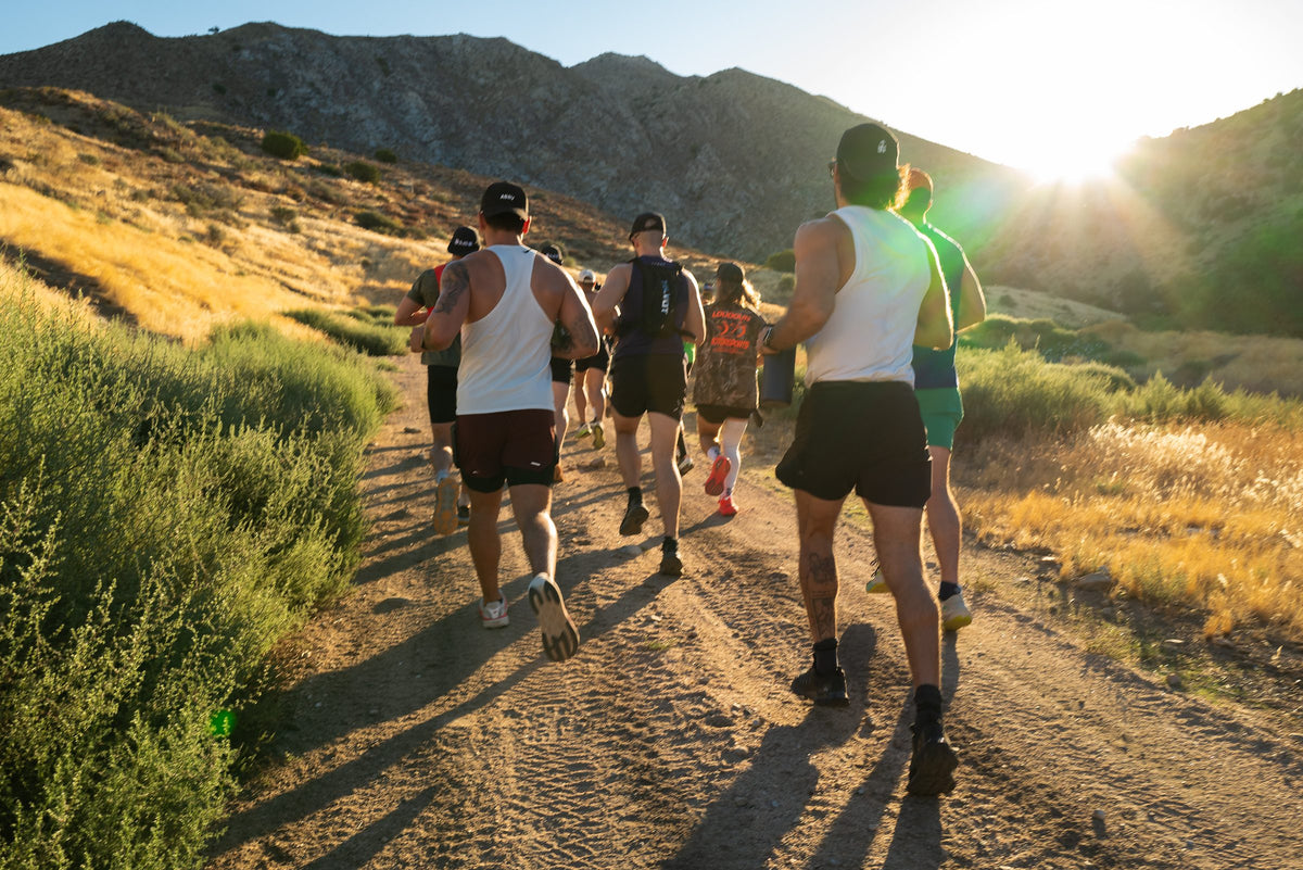 Athletes hiking a mountain trail at sunset